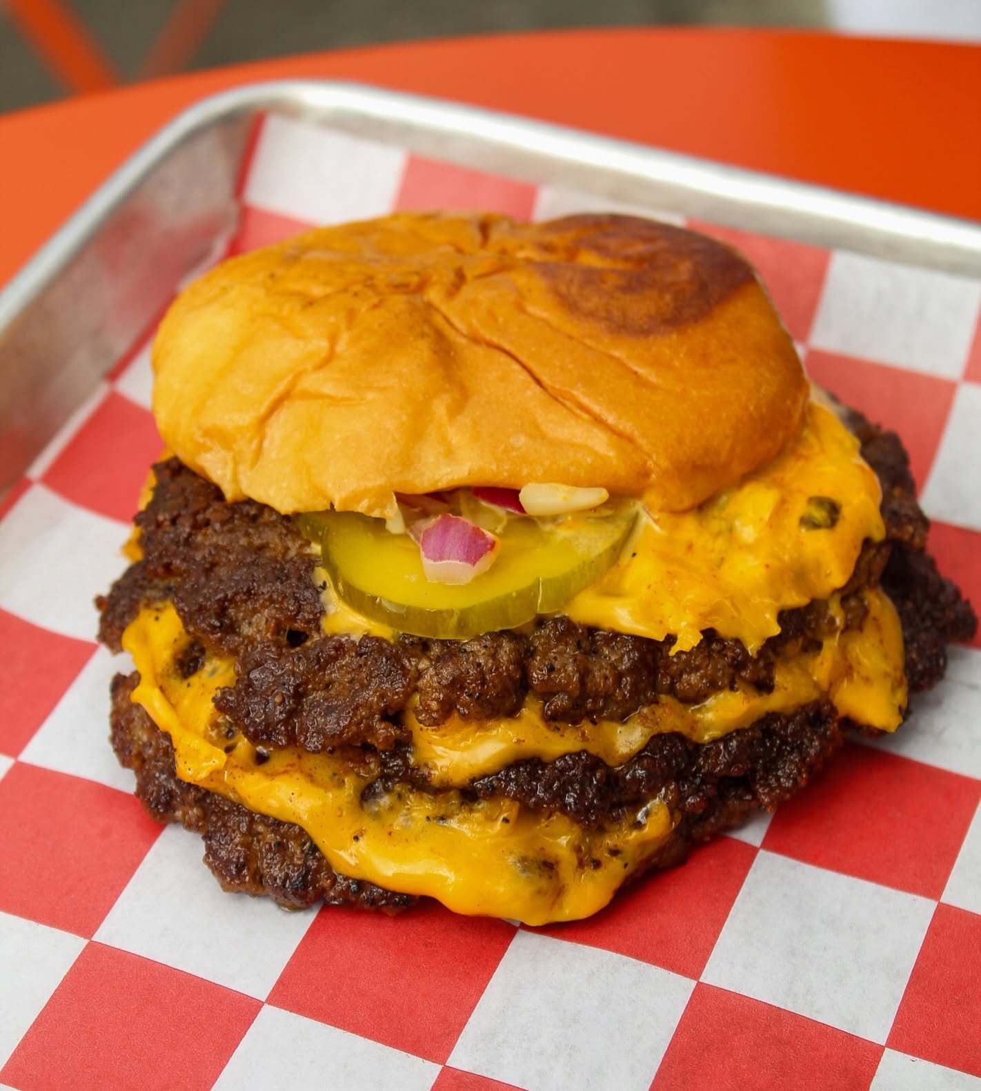 Triple smash burger stacked with melted cheese
